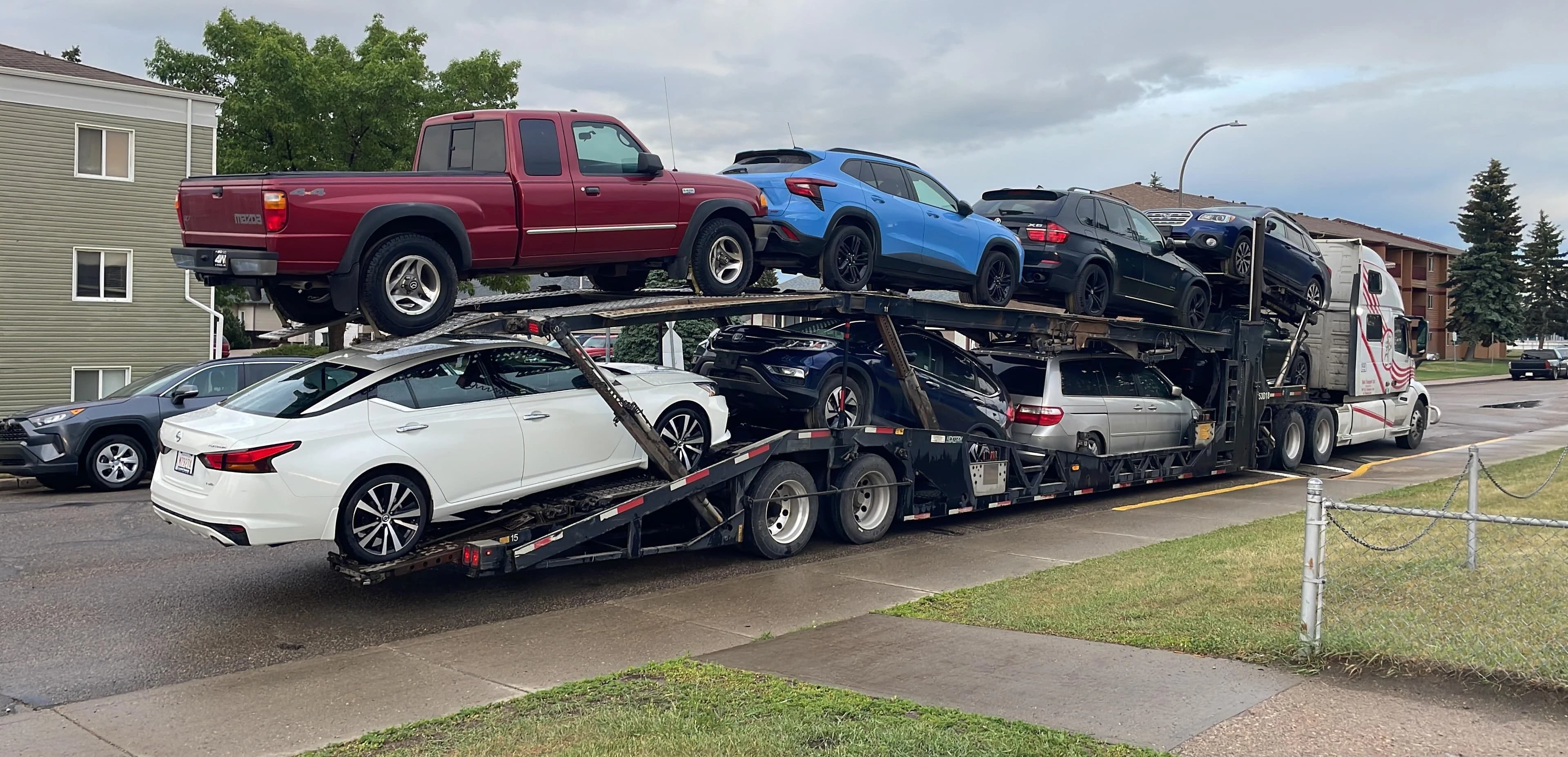 Interlane multi-car carrier loaded with SUVs, a pickup truck, and other vehicles