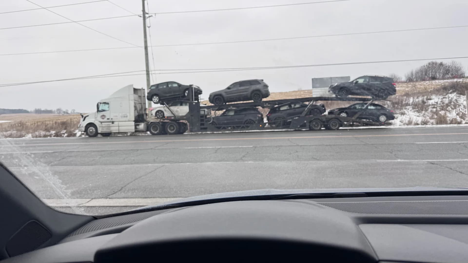 Open auto hauler transporting vehicles on highway