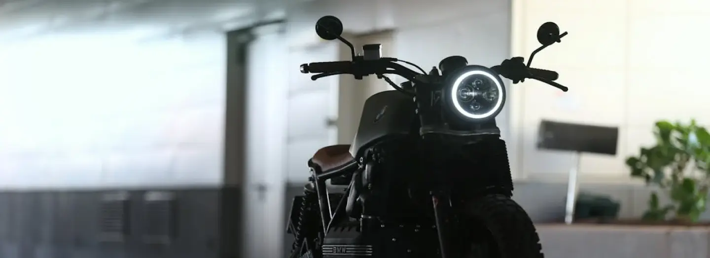 Open trailer transporting a motorcycle secured with straps