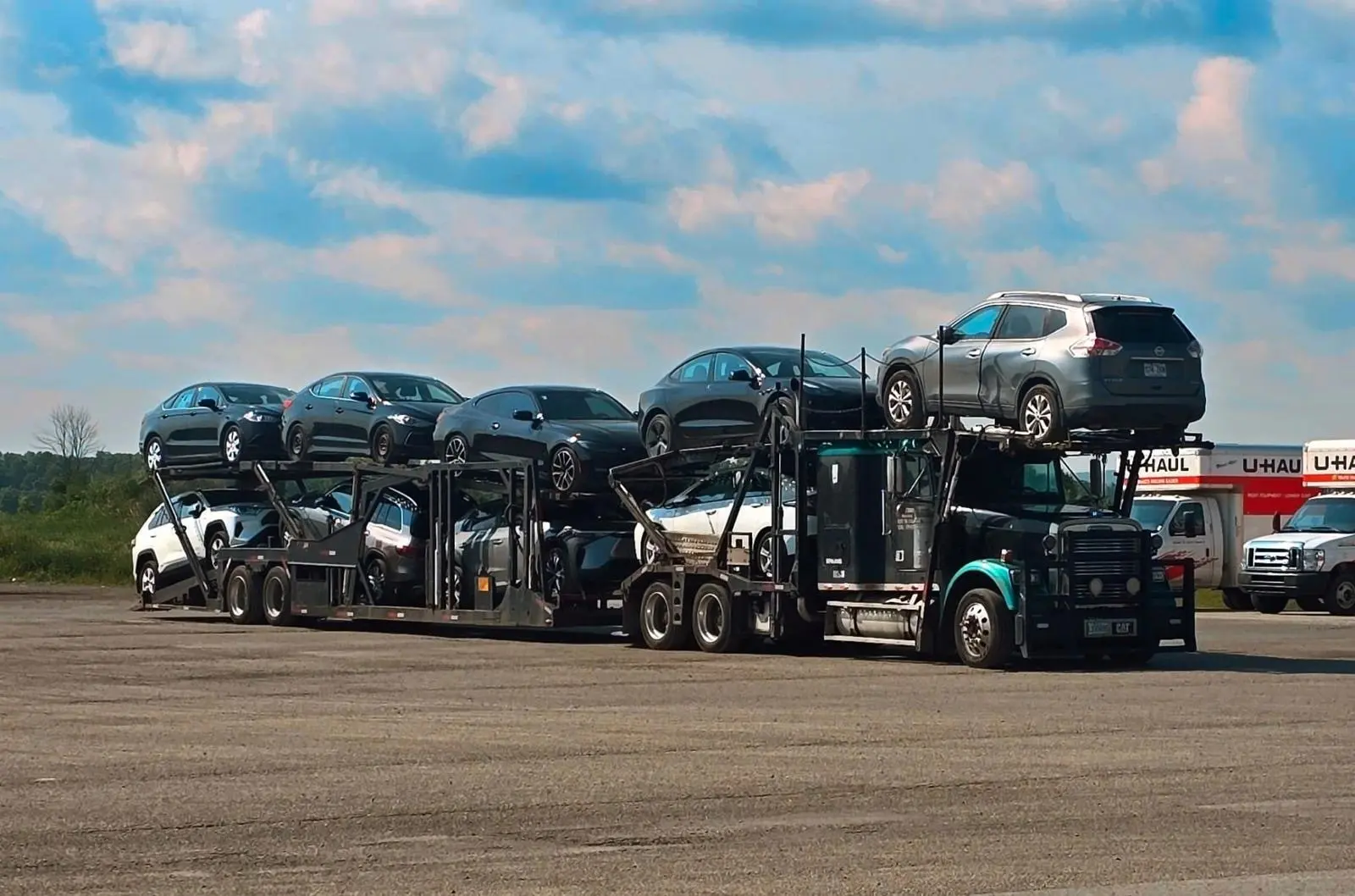 British Columbia car shipping with scenic background of coastal highway and vehicle transporter