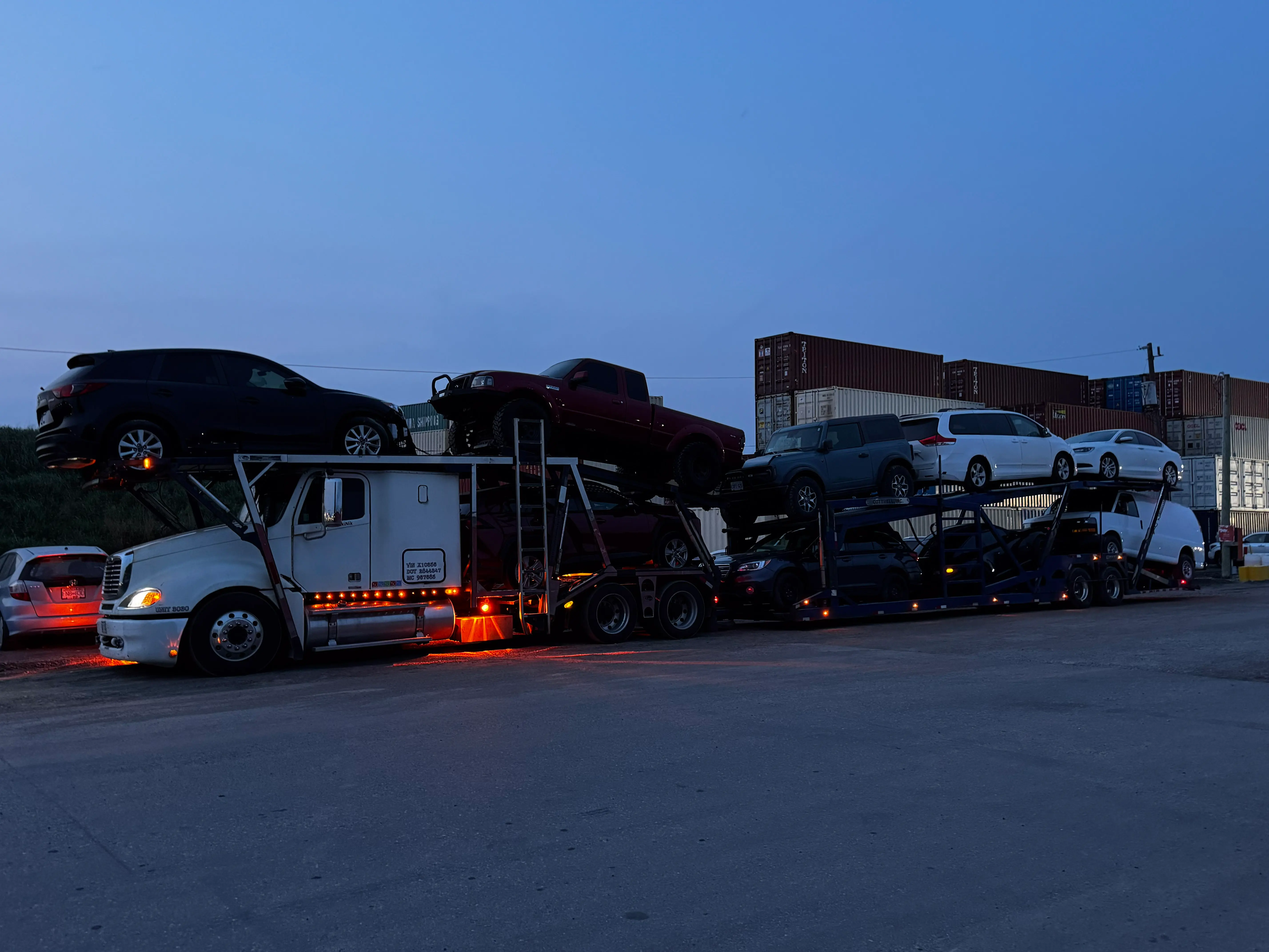 Car transporter driving through scenic coastal route in Nova Scotia