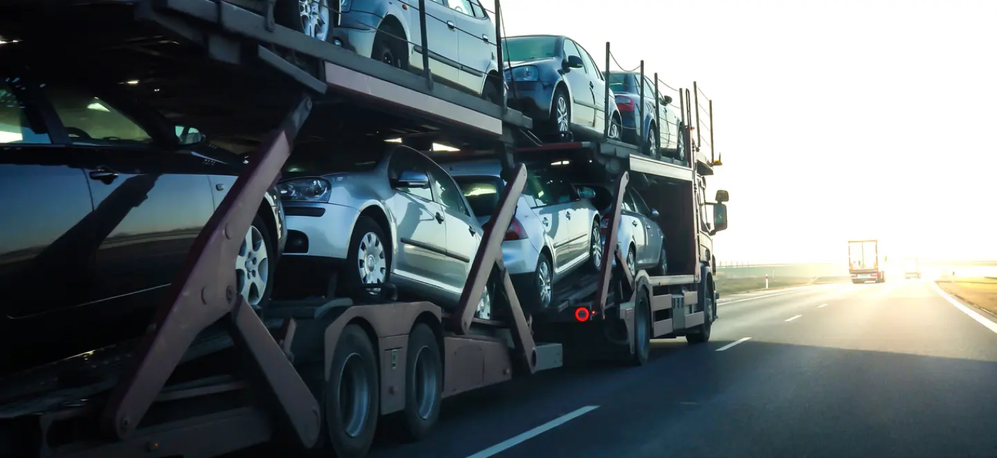 Damaged car being winched onto a flatbed trailer for transport